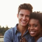 Mixed race couple in the countryside, looking to camera