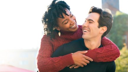 interracial couple with the black woman getting a piggyback ride
