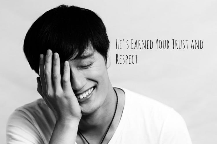 Portrait of young man covering his face and smiling, black and white style