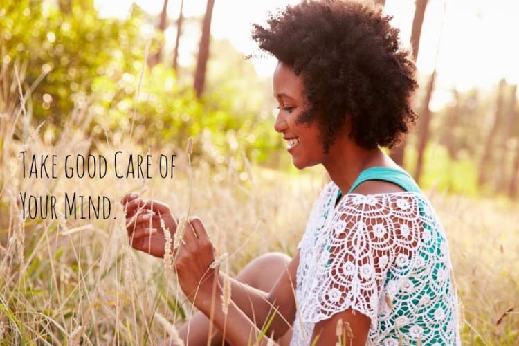 Portrait Of Smiling Young Woman Sitting In Countryside