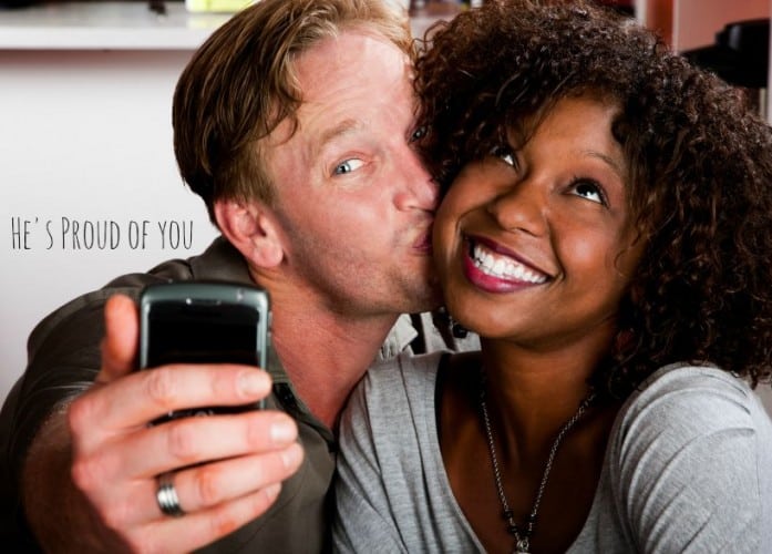 Caucasian man and African American woman taking picture in coffee house with cell phone