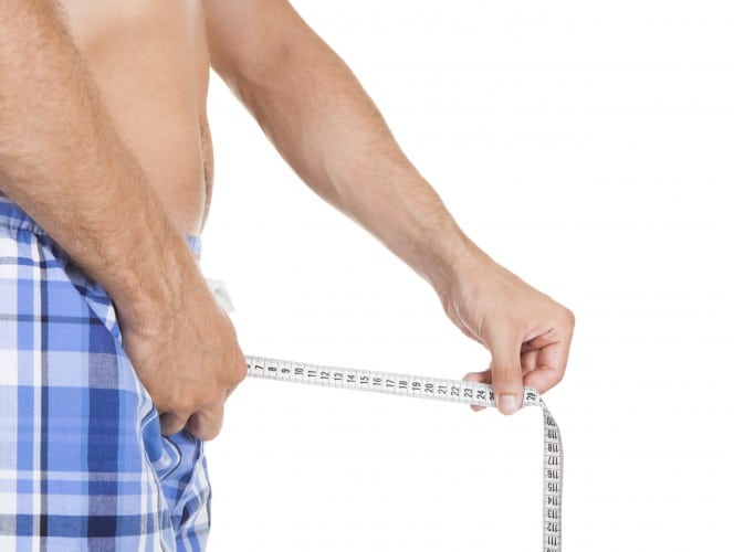 Man measuring his penis size with measurement tape