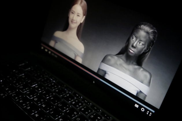 An online advertisement by Thai cosmetics company Seoul Secret showing Thai actress Cris Horwang, right, is displayed on a computer screen in Bangkok, Thailand, Friday, Jan. 8, 2016. The company has pulled a video in which the Thai movie star wears blackface and promotes a skin-whitener with the slogan: 