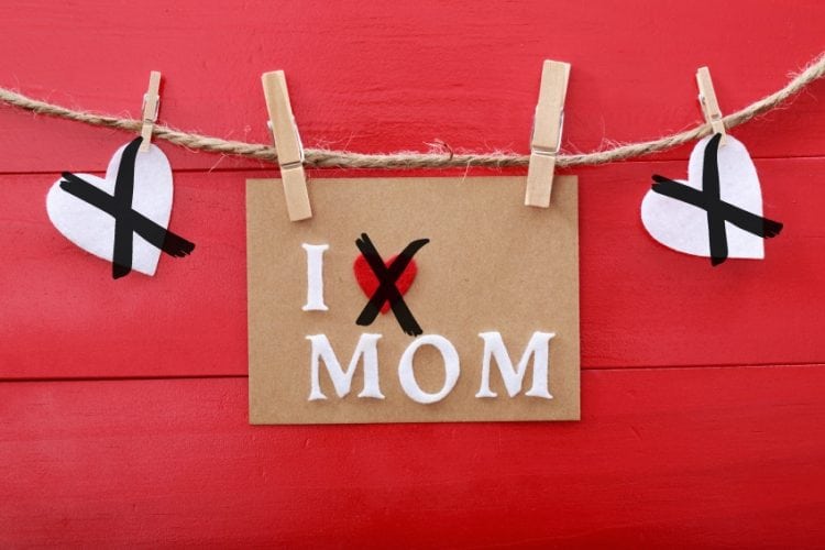 Mothers day message with felt hearts hanging with clothespins over red wooden board