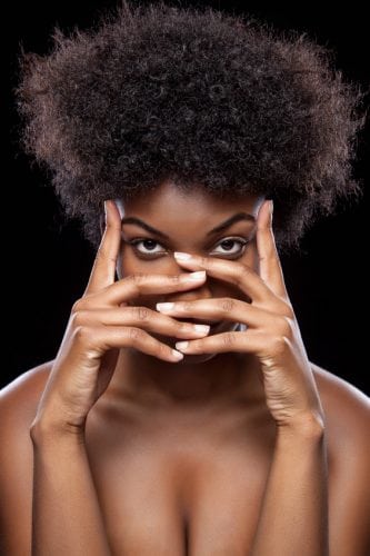 Young African beauty covering face with hands