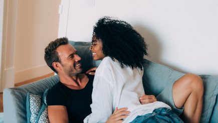 interracial couple cuddling on a couch