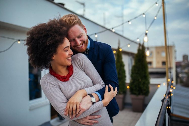 interracial couple embracing on a balcony