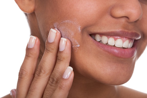 closeup of a woman applying facial essence